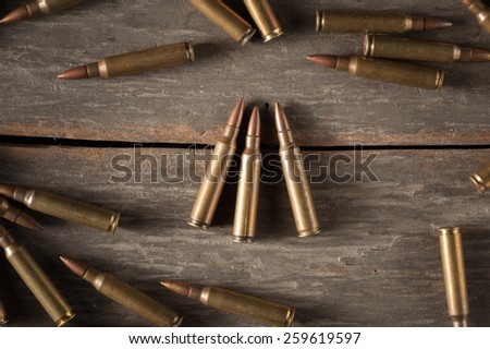 Rifle bullets on wood table with low key scene
