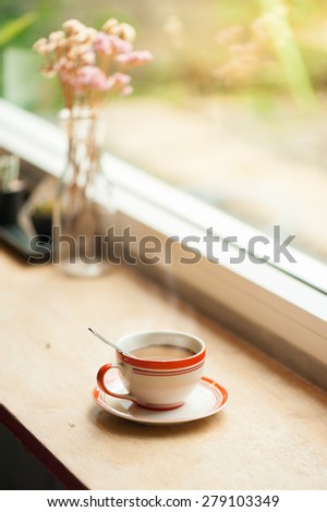 Milk coffee in coffee cup on wood bar with morning scene