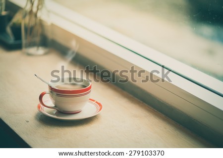 Milk coffee in coffee cup on wood bar with morning scene