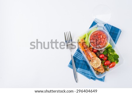 Grilled salmon with tomato salsa and salad cooked by clean food concept in lunch box