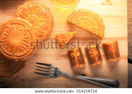 Moon cake, Chinese mid autumn festival dessert on wood board with dramatic morning scene