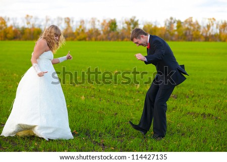 bride and groom dancing merrily in green field, couple, wedding fall