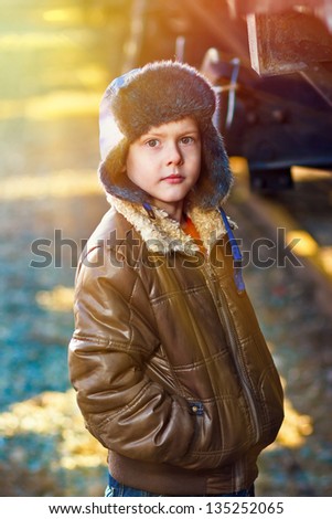 sunlight Boy homeless bum on street freezing close to railway carriage hat and jacket