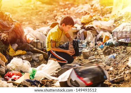 sunlight german homeless boy child blonde in yellow a jersey at garbage dump looking for food