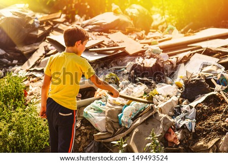 sunlight german homeless boy child blonde in yellow jersey a at garbage dump looking for food