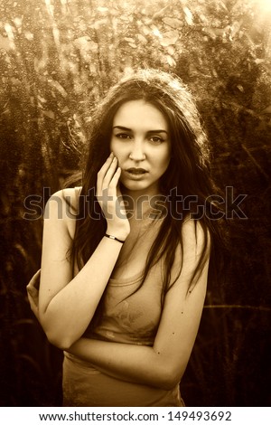 retro sepia portrait of a beautiful young woman hippie girl in nature on green grass in summer