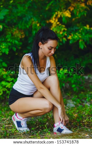 running tying woman shoes sports shoe sport runner up athlete jogging female fitness sitting in the green forest