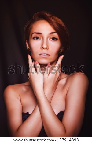 portrait of a beautiful brunette woman girl model on a black background, large hands and face hair