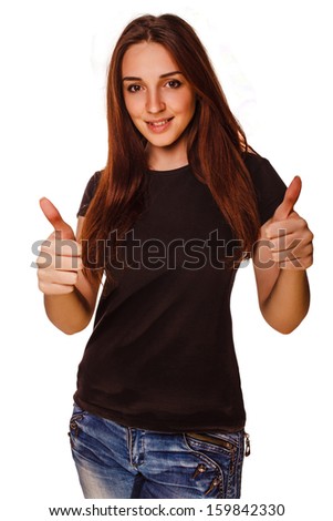 happy young woman girl shows positive sign thumbs yes, in a gray T-shirt and blue jeans isolated studio