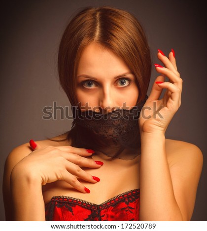 woman girl in a red corset, her mouth covered with a bandage, a symbol of silence and stillness, unusual art photo large