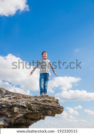 teenager suicide acrophobia boy man stands on the precipice of a cliff height and fear of heights on a background of blue sky
