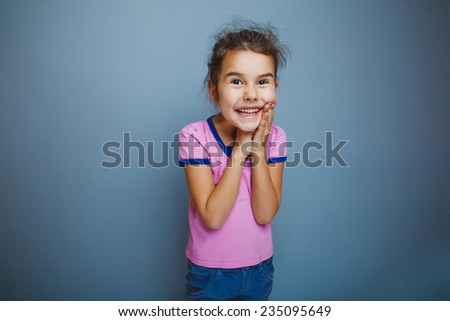 the girl child is happy surprise on a gray background