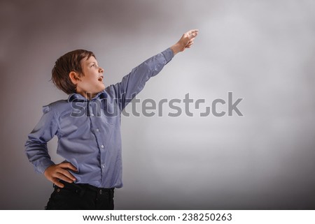 adolescent boy brown experiences happiness showing thumb up on a gray background