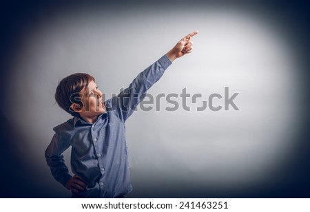 teenager boy of 10 years of European appearance showing thumb up, points cross process
