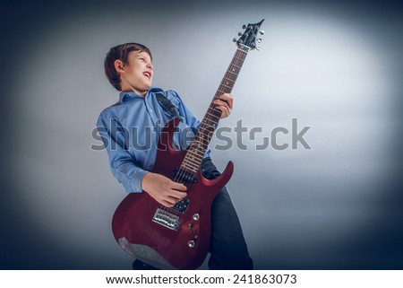 boy teenager European appearance brown emotionally plays guitar cross process