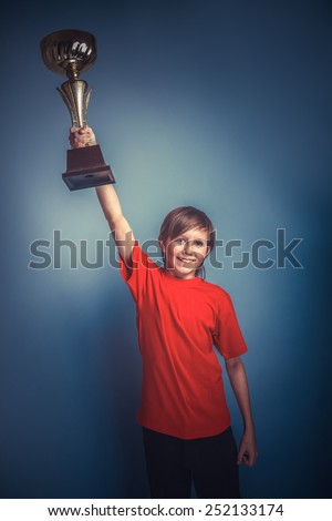 European- looking  boy of ten years cup, sports, award on a gray background retro