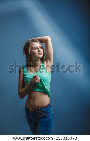 woman in blue jeans in a green shirt looking  away