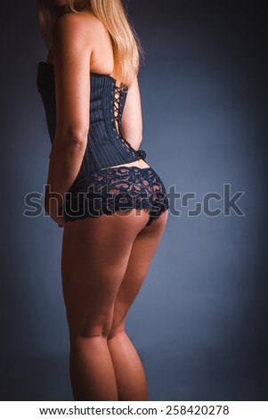 woman in lingerie, back, ass on a gray  background