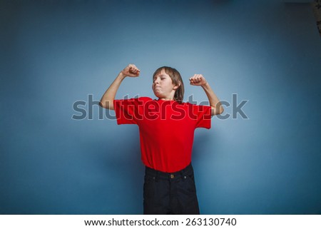 The boy, a teenager in a red t-shirt shows the strength of the hands