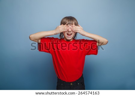 boy in red t-shirt teenager brown hair European appearance closed eyes opened his mouth hands on a gray background, cry
