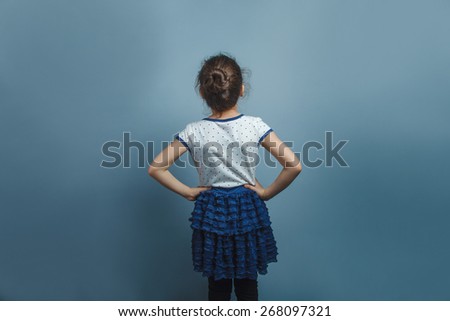 Teen girl of European appearance five years worth  of back to the camera on gray background