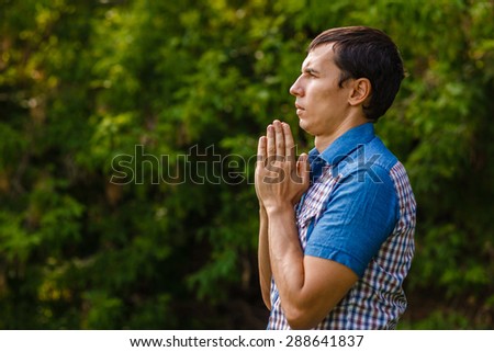 The man in the street to pray to God on a green background leaves  summer
