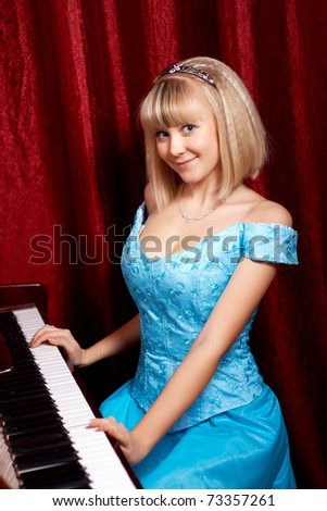 woman in blue dress playing the piano