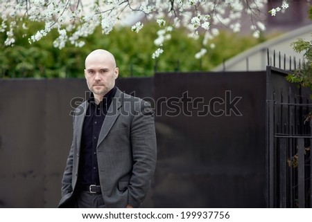Portrait of an handsome businessman. Handsome mature man standing in front of a house.