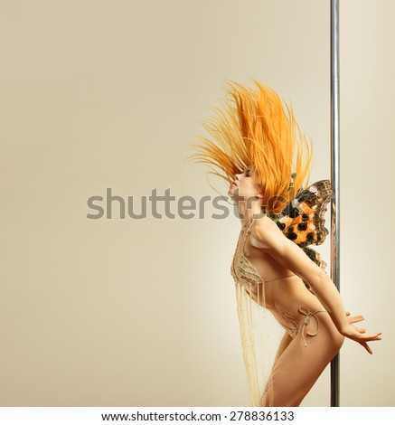 Young long haired woman with butterfly wings at a pole