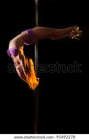 Bow. Young redhead woman hanging on a pole upside down