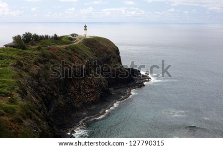 A lighthouse at the end of a point into the Pacific Ocean on Hawaii\'s westernmost island of Kauai.