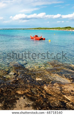 Red life raft in clear sea water