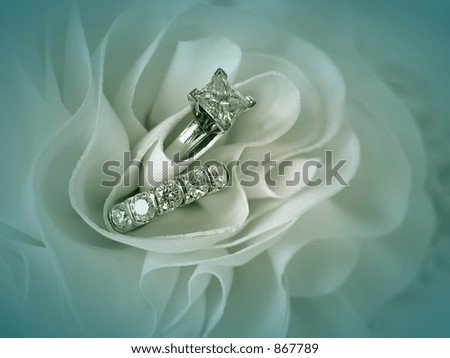 stock photo Soft blue vignette image of wedding rings in the folds of the 