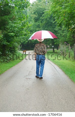 Walking in the forest on a rainy day with a large umbrella.
