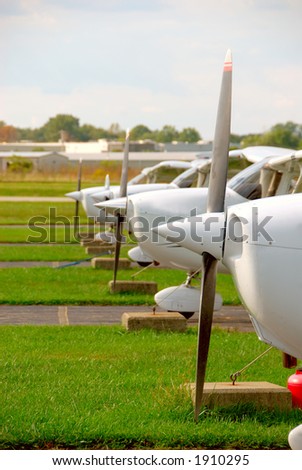 Small Plane Props - The propellers and noses of cessna skyhawk airplanes parked and tethered at a small airport.