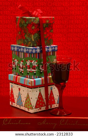 Holiday Gifts - Festive gift boxes and a glass of merlot wine against a cheerful holiday background.