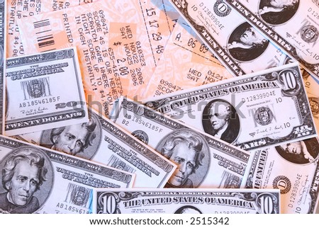 Macro background of lottery tickets and cash winnings in tens and twenties US currency.