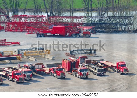 Aerial, view of trucks, cranes and lifts at a riverside trucking company.