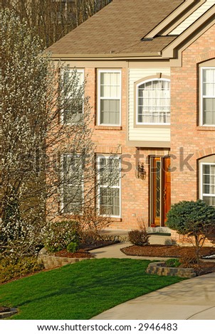Exterior of the front entry of a brick home in the suburbs.