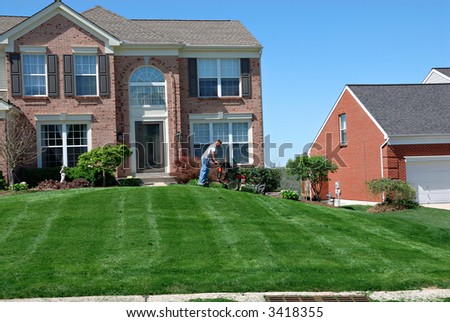 Mowing The Lawn - Professional lawn care service using a riding lawn mower to cut the grass.