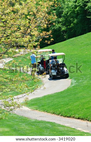 Golfers using golf carts to get around the golf course.