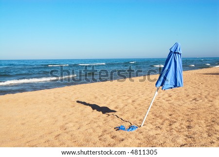 Umbrella in the Sand at Lake Michigan, USA - A beach umbrella in the sand at a deserted Lake Michigan beach in summertime.
