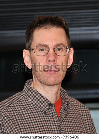 Headshot of an adult man wearing glasses