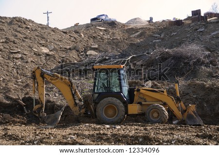 Construction Heavy Equipment - a construction site on a hillside with rocks and mud.