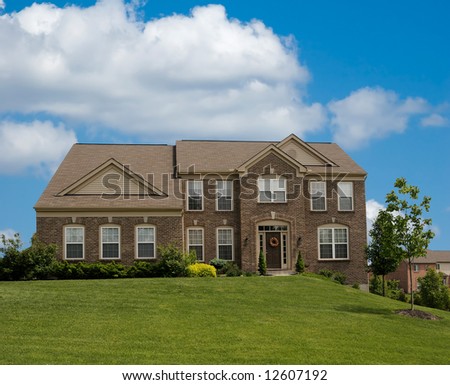 Brick Suburban Home on a cloudy spring day.