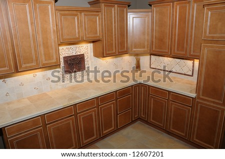 Luxury kitchen in an upscale house with maple cabinets and tile counter tops and floors.