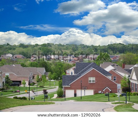 stock photo The Suburbs A Community of Brick Suburban Homes on a cloudy 