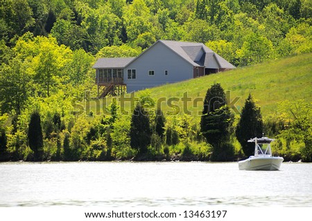 A home overlooking a small lake in Kentucky, USA with a boat in the water in the foreground.