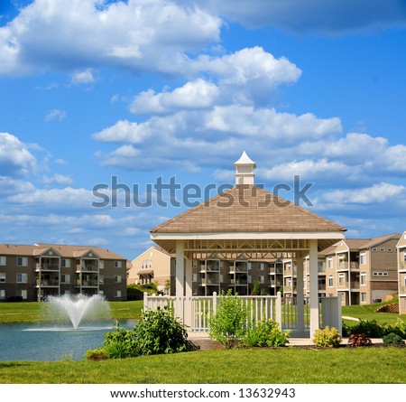 Condo apartment homes overlooking a small lake with a gazebo and fountain in Kentucky, USA.