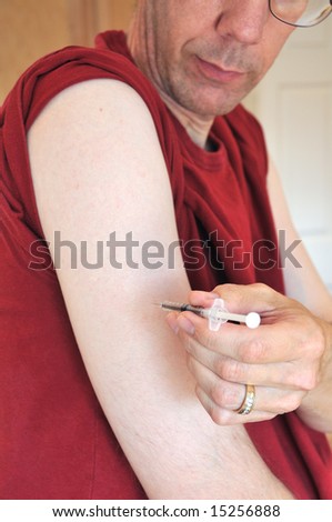 Allergy Syringe Self Injection - Person injecting a dose of allergy medication into his arm using a syringe.